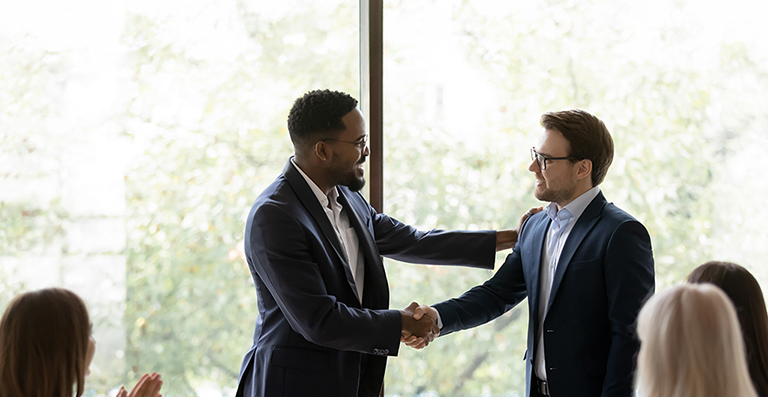 two professionals shaking hands for their law firm merger